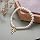 Pulsera de perlas delicadas con amuleto de lazo dorado