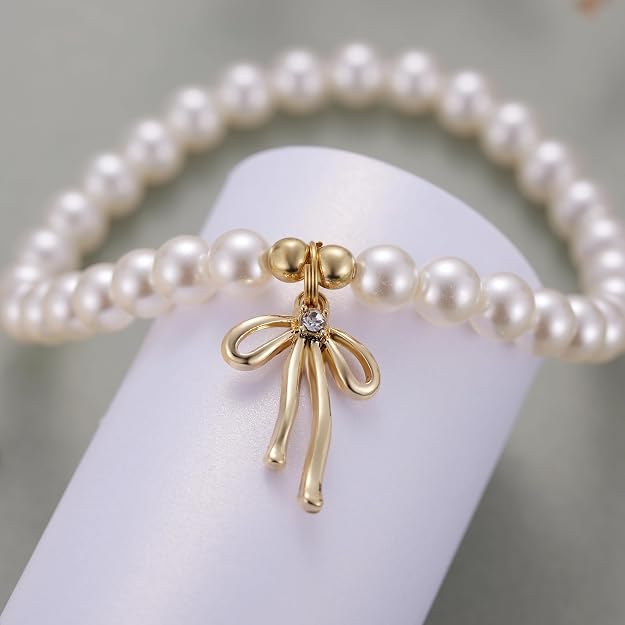 Pulsera de perlas delicadas con amuleto de lazo dorado